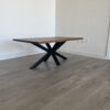 A sleek and modern Ready To Ship - Black Walnut Coffee Table featuring a rectangular top and black angular legs graces a light gray wood floor against a plain white wall. Nearby, electrical outlets are visible on the wall. This stylish piece is ready for your immediate enjoyment.
