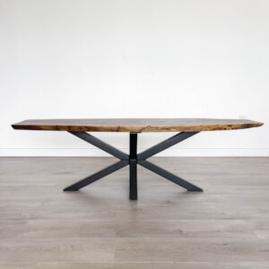 Introducing the Ready To Ship - Black Walnut Live Edge Coffee Table: a minimalist design crafted from rich black walnut wood and featuring black crisscross metal legs. This elegant piece is ready to ship and rests beautifully on a light gray hardwood floor against a plain white wall.